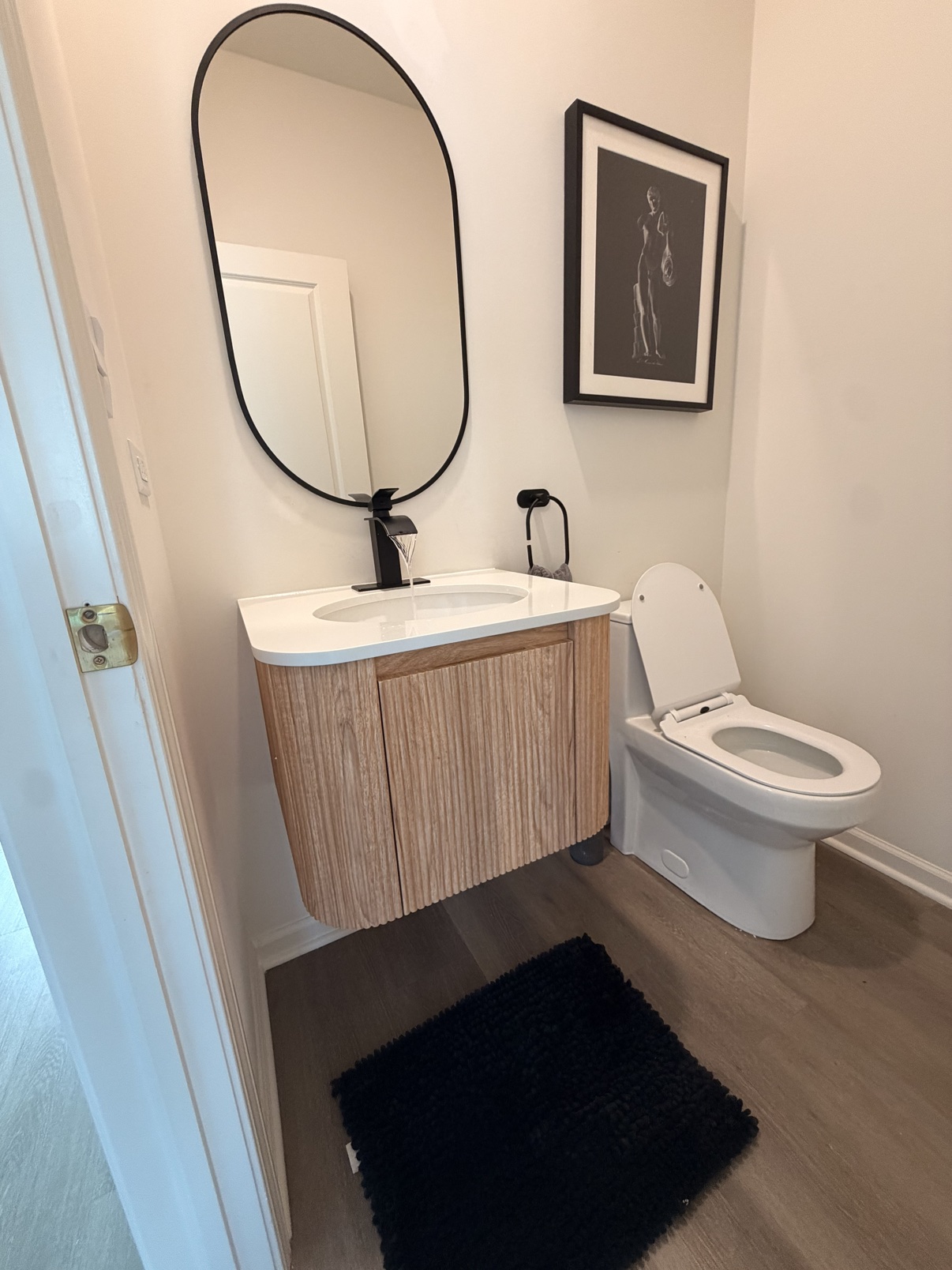 After: new floating vanity with mirror and black fixtures
