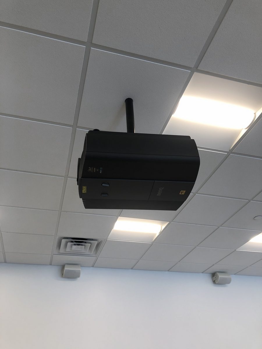 Ceiling-mounted projector in a commercial office with tile ceiling