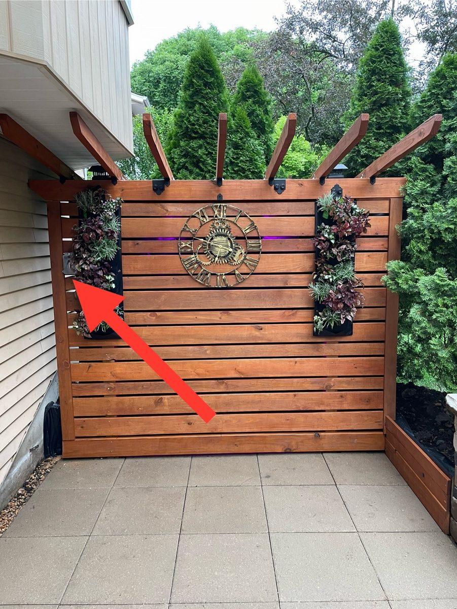 Patio privacy screen with outdoor speakers installed behind planters
