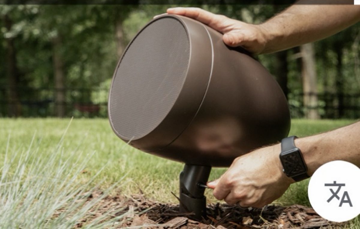 Close-up of a garden spike speaker set into a mulched bed