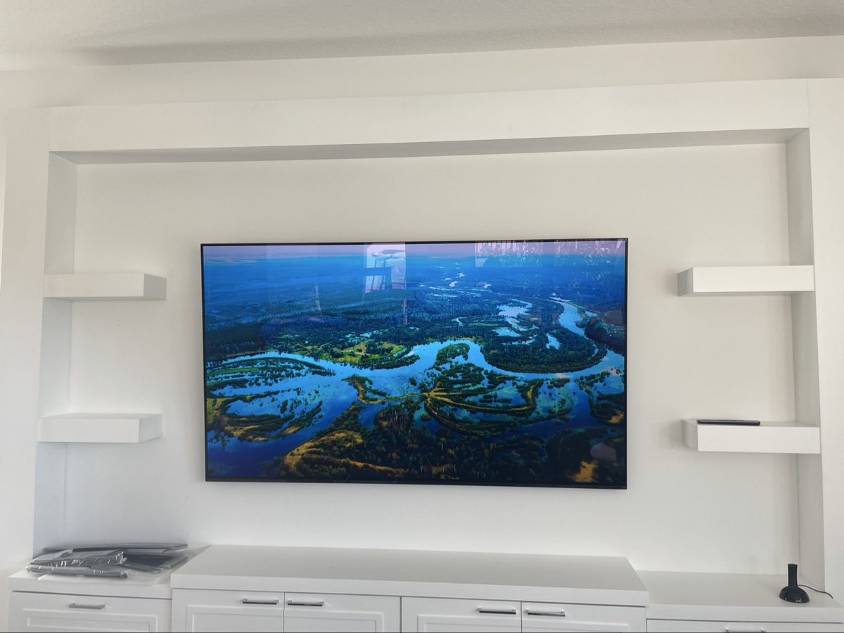 TV mounted on a custom media wall with floating shelves