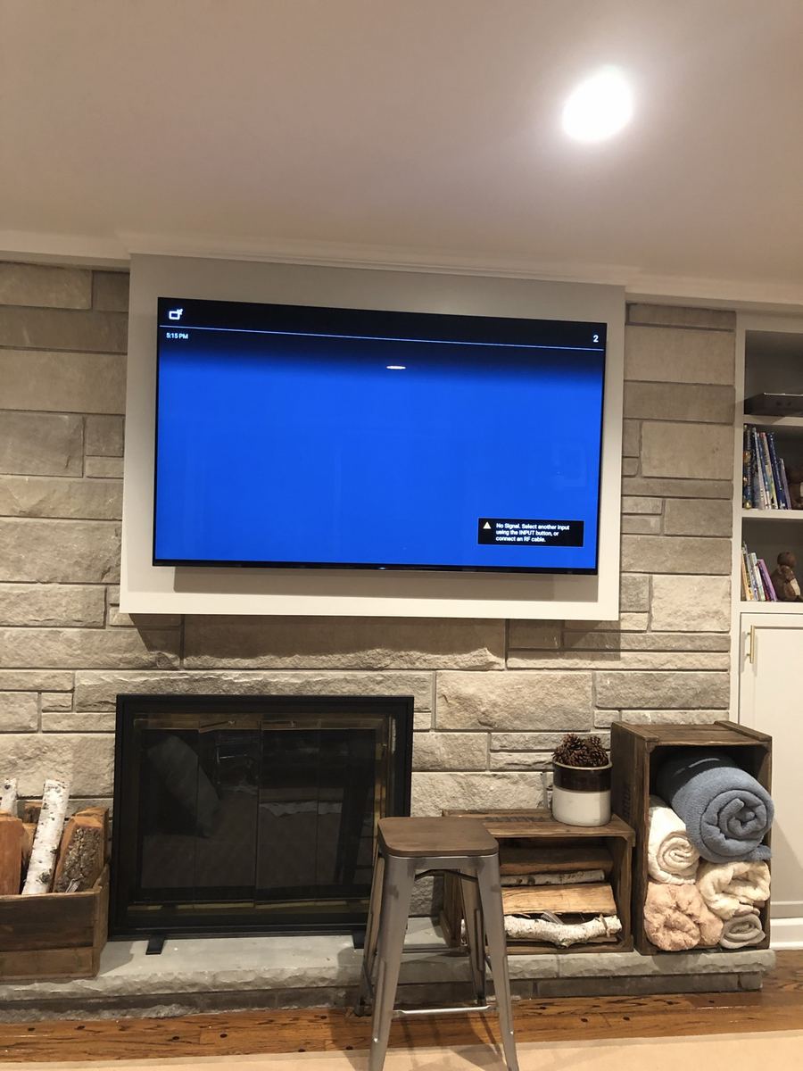 TV mounted above a stacked-stone fireplace in a living room