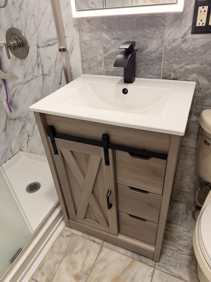 After: new light-wood barn-door vanity with black faucet